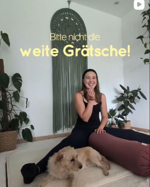 Sophie sitzt lachend auf der Matte, ihr Hund liegt neben ihr