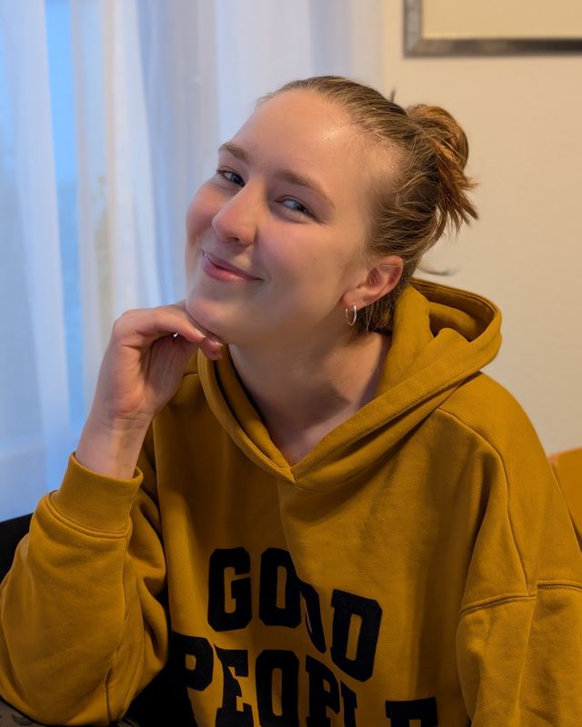 Sophie lächelt in einem senffarbenen Hey-Honey-Hoodie